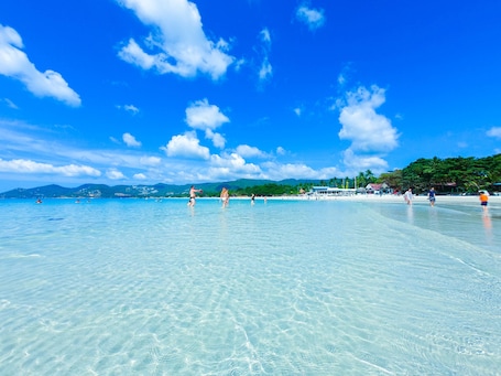 On the beach, white sand, sun loungers, beach umbrellas