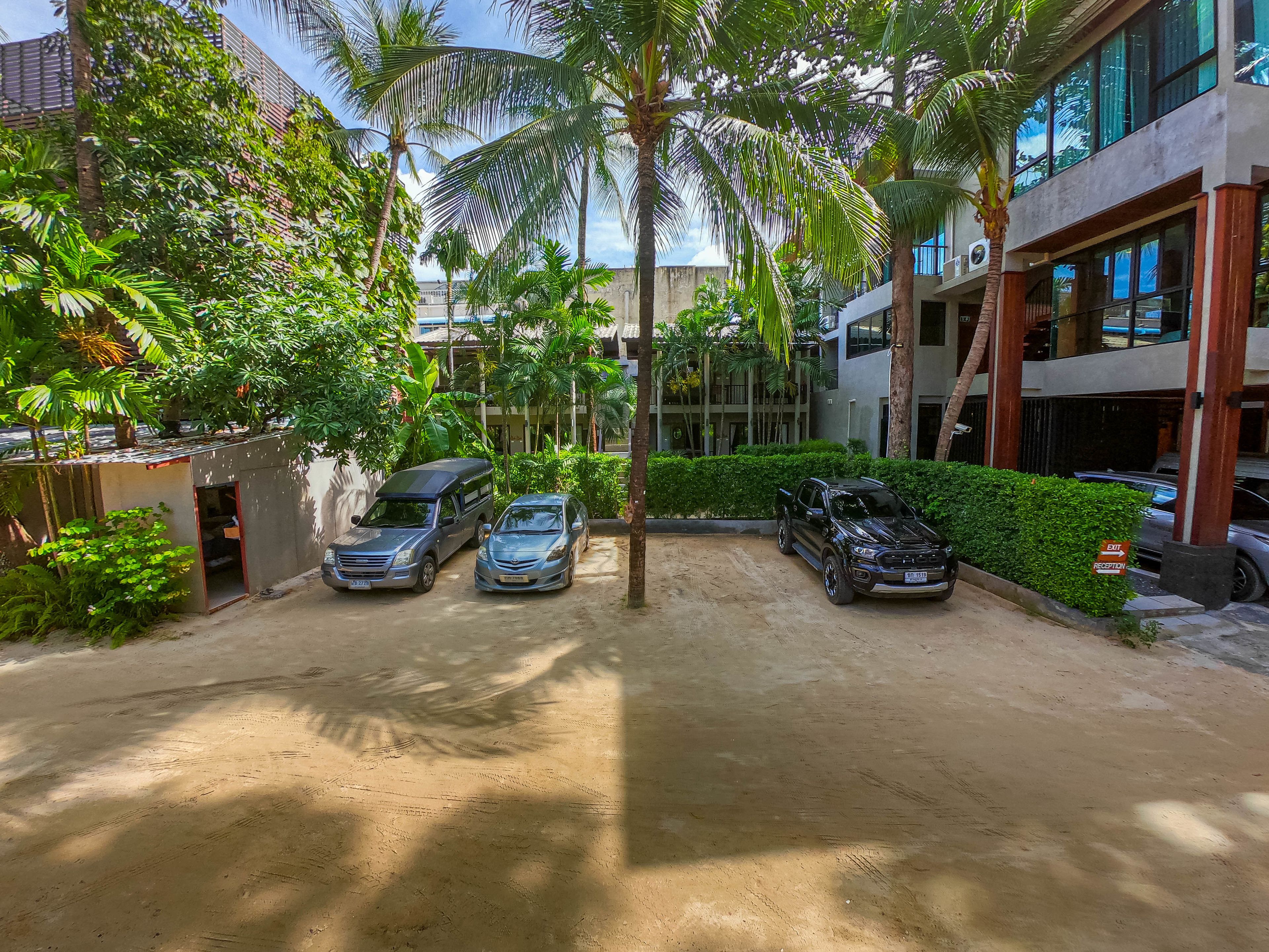 A parking area with two cars and a small structure.