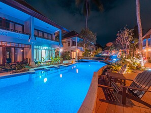 Relax by the pool surrounded by modern buildings with spacious balconies.