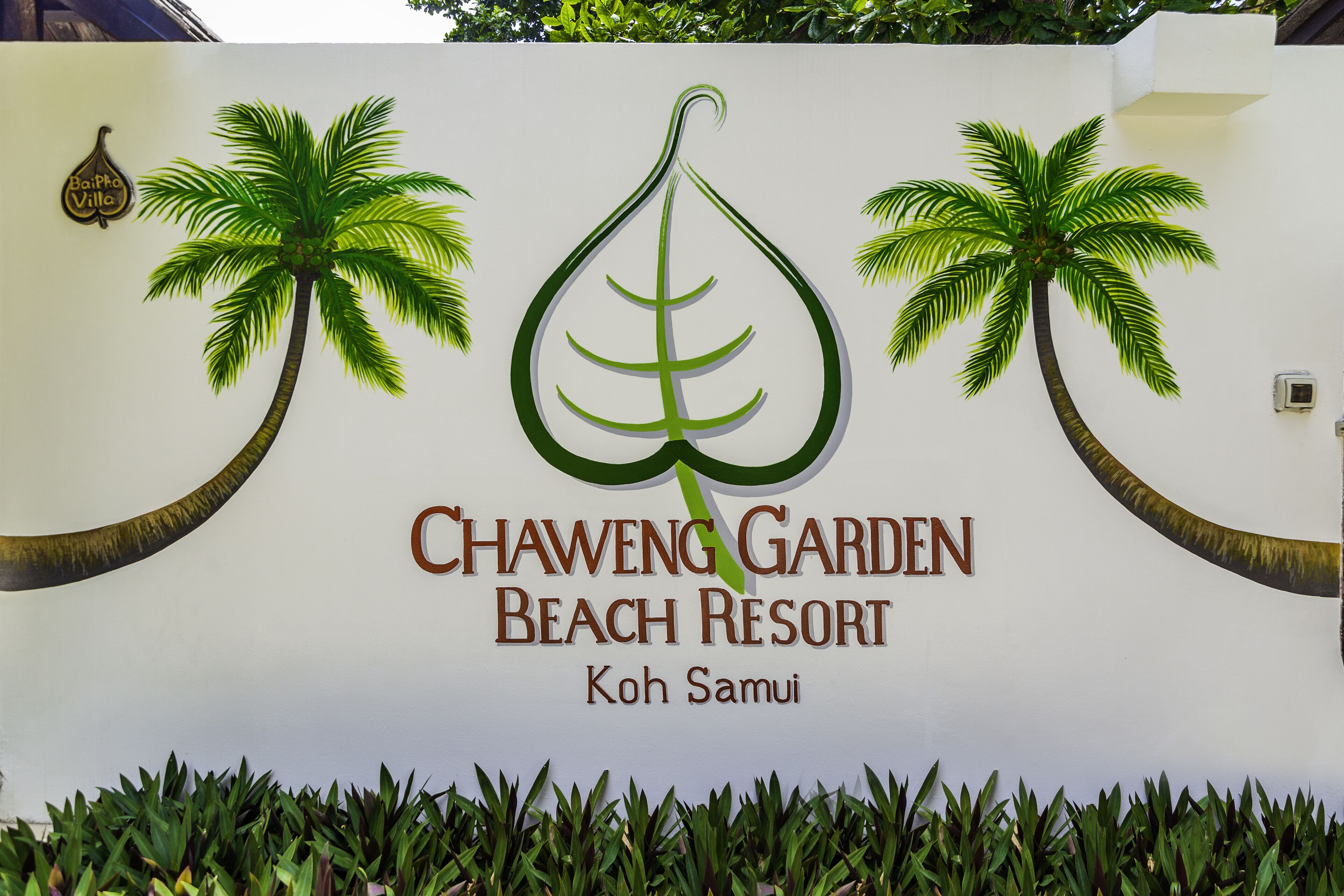A sign for Chaweng Garden Beach Resort with palm tree graphics and the resort's name.