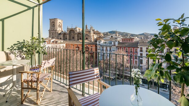 A balcony with a view of a historic church, a table, and chairs. - U-Sense Granada Centro (Granada)