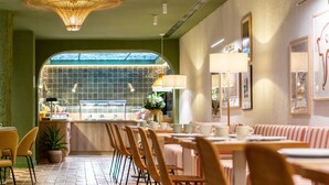 A restaurant with a tiled floor, wooden chairs, and tables with striped tablecloths. - U-Sense Granada Centro (Granada)