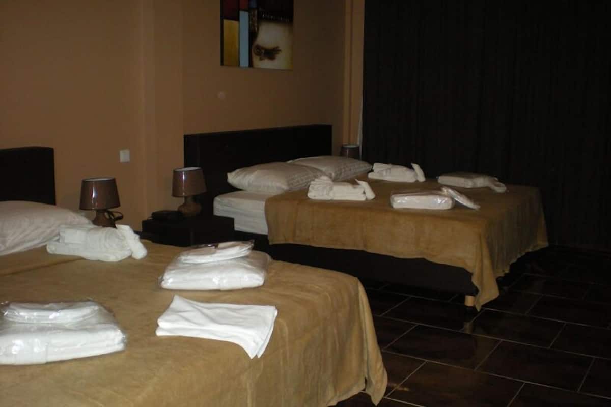 Una habitación de hotel con dos camas, cada una con toallas ordenadas y almohadas.