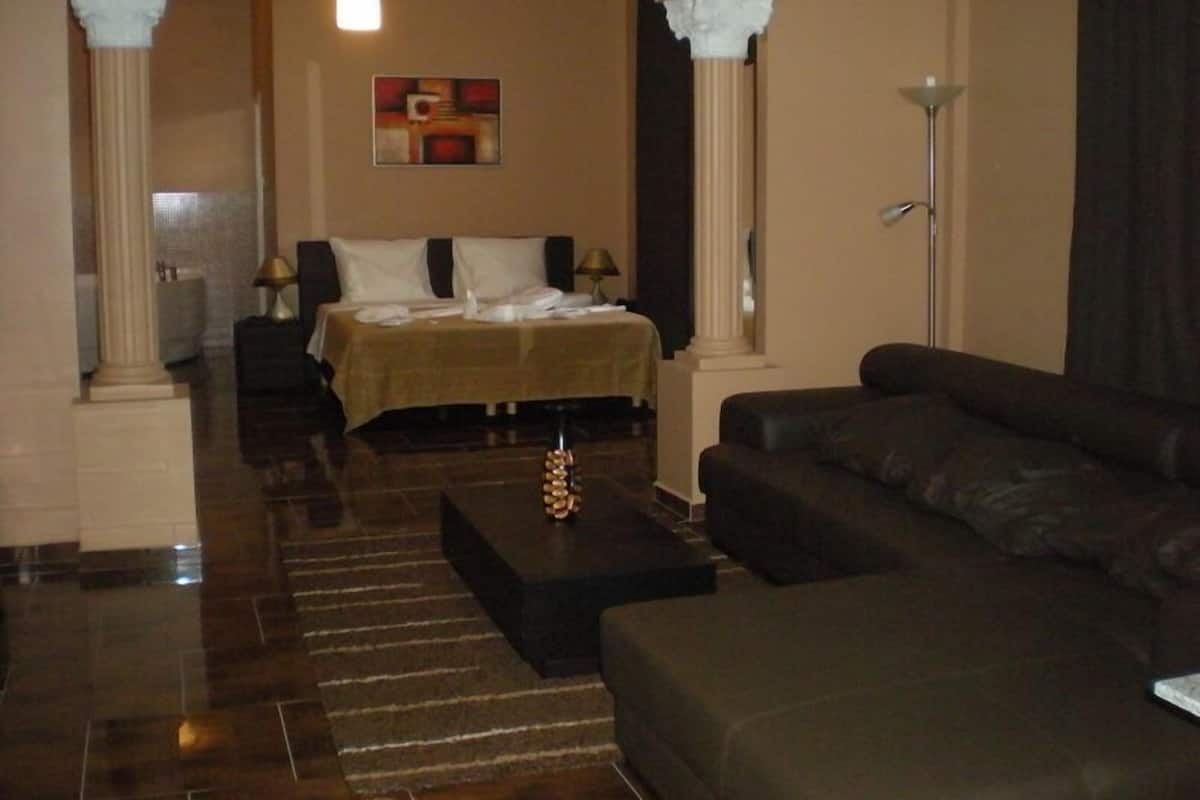 Una habitación de hotel con una cama, un sofá, una lámpara y un cuadro en la pared.