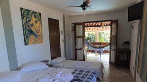 Habitación de hotel con dos camas, ventilador de techo, televisor y vistas al exterior.