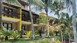 Un patio de hotel con piscina, palmeras y una hamaca.