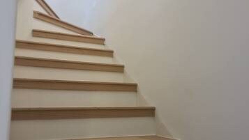 A staircase with wooden steps and white walls.