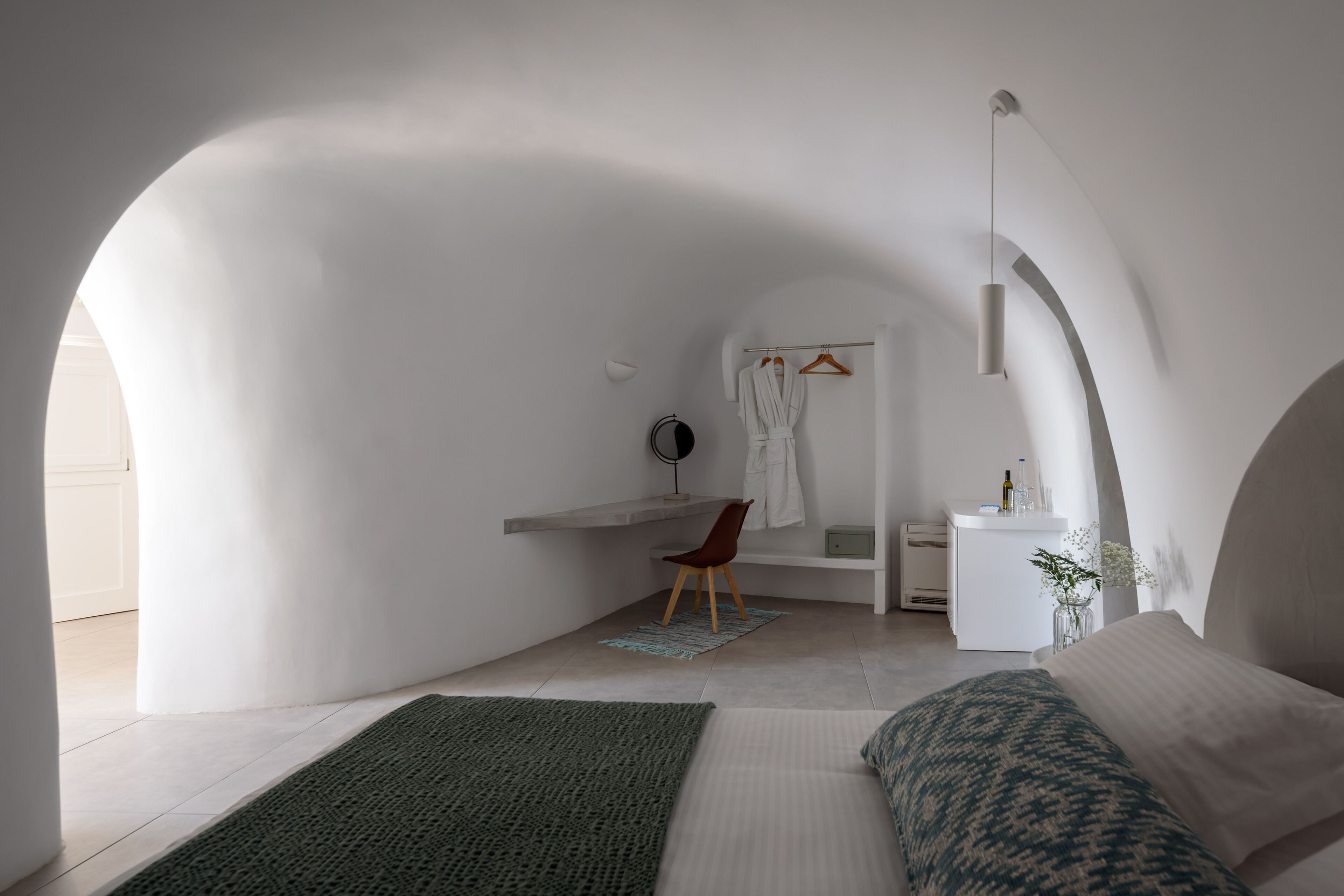Un dormitorio minimalista con cama, escritorio y silla.