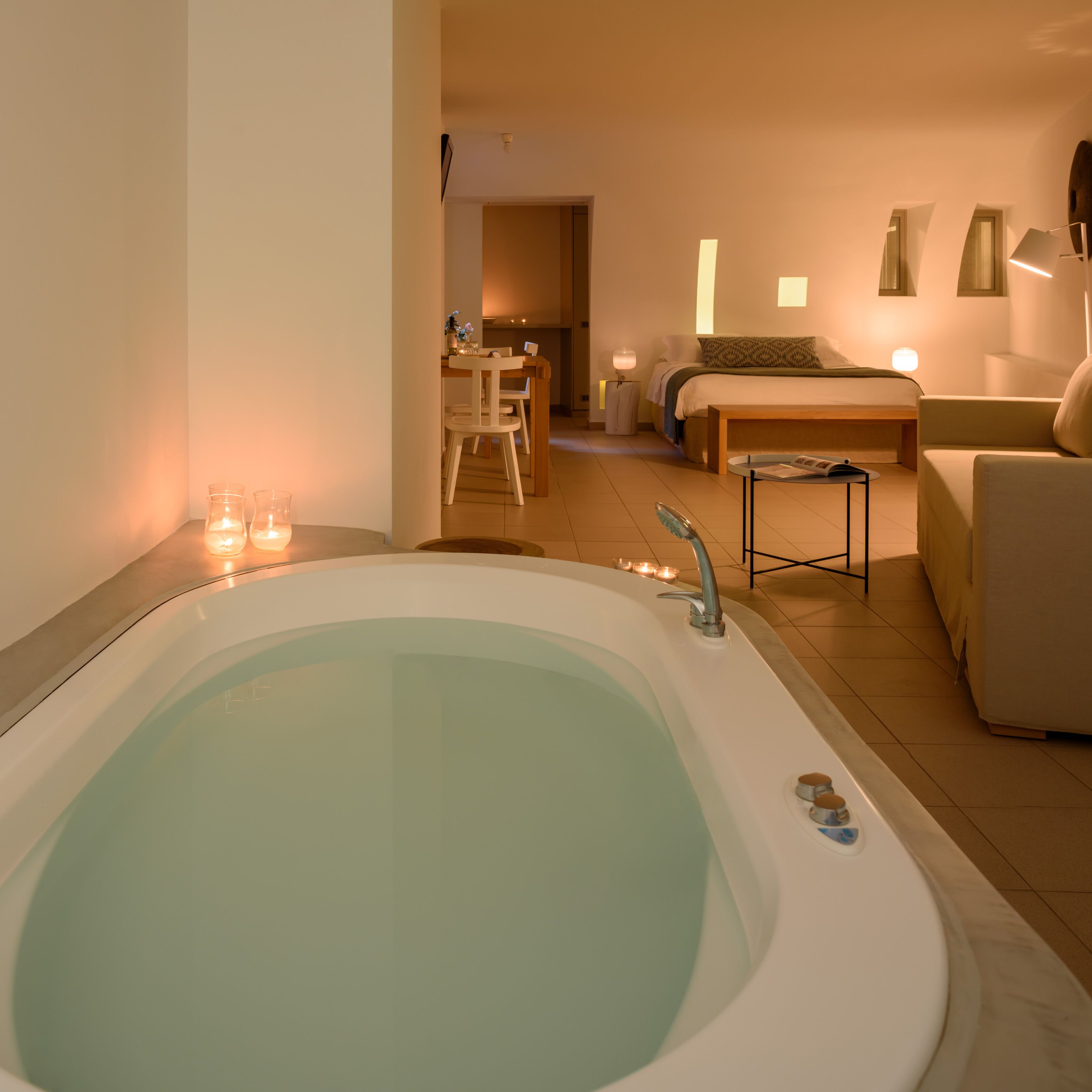 Ein modernes Badezimmer mit einer großen Badewanne, einem kleinen Tisch und einem Stuhl.