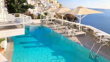 Una piscina al aire libre de temporada, sombrillas