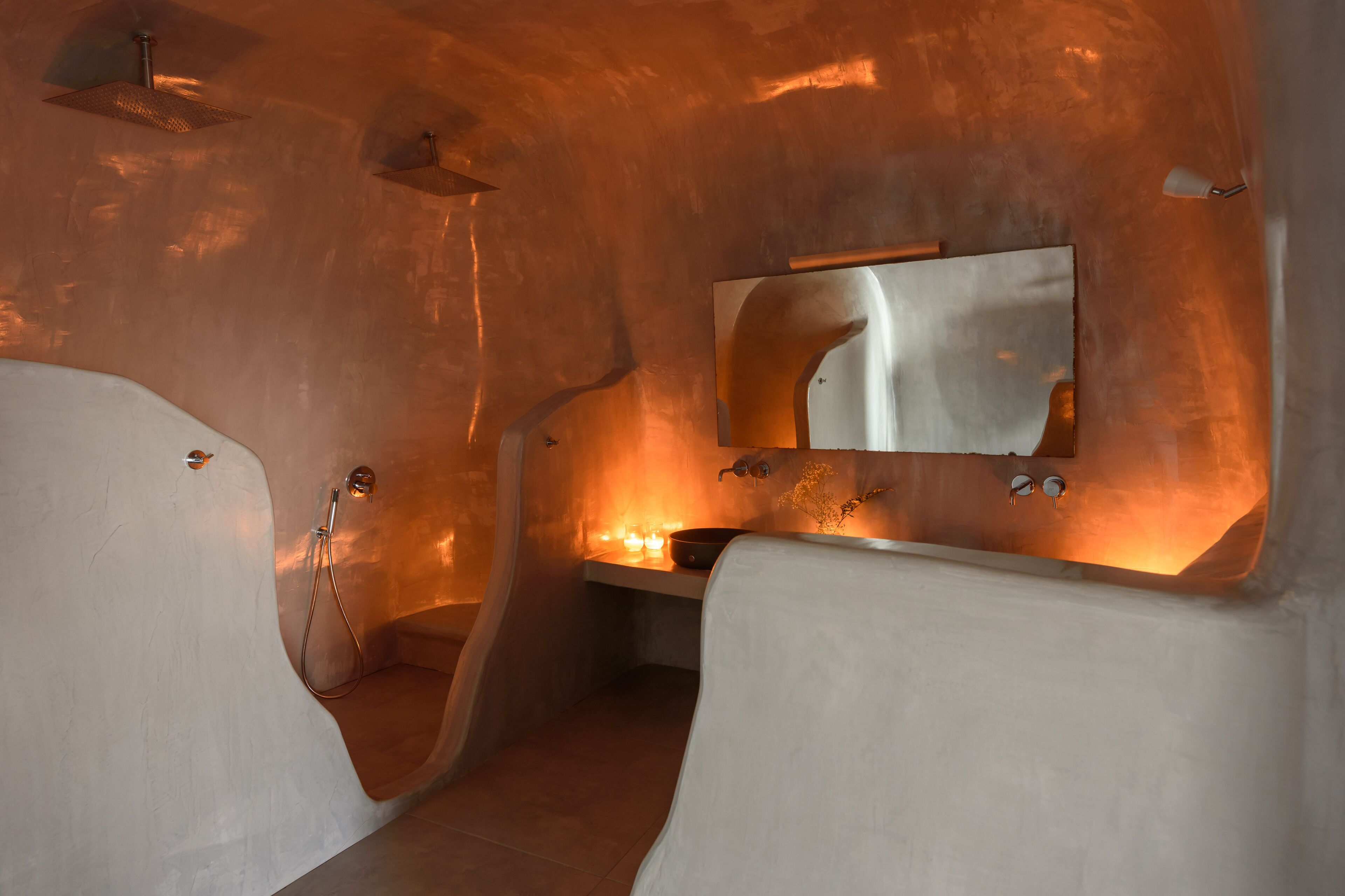 Un bagno moderno con un design curvo originale, uno specchio grande e un angolo doccia.