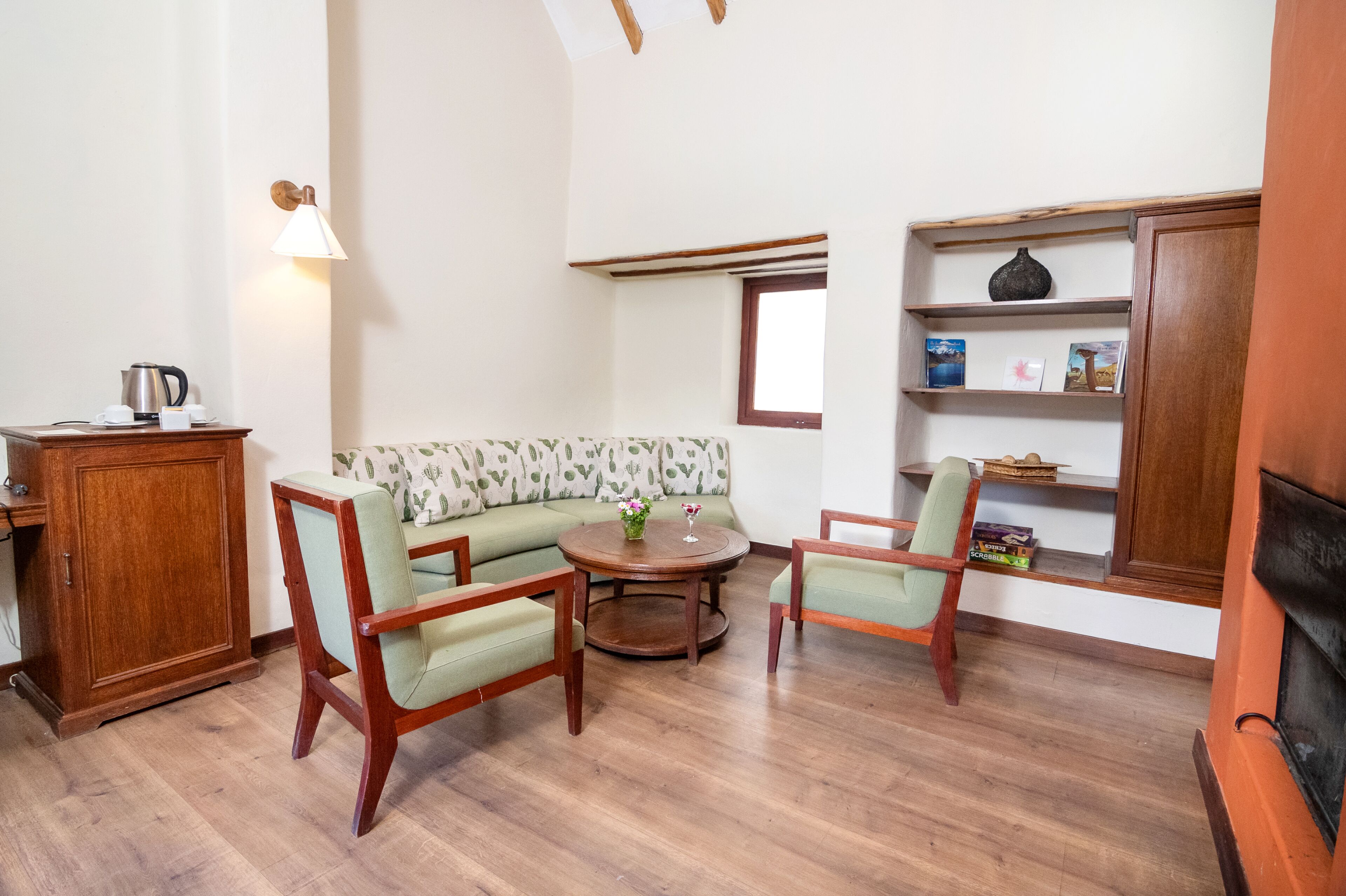 A cozy living room with a sofa, two armchairs, a coffee table, and a wooden cabinet.