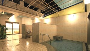 A clean indoor swimming pool area with tiled walls and a tiled floor.