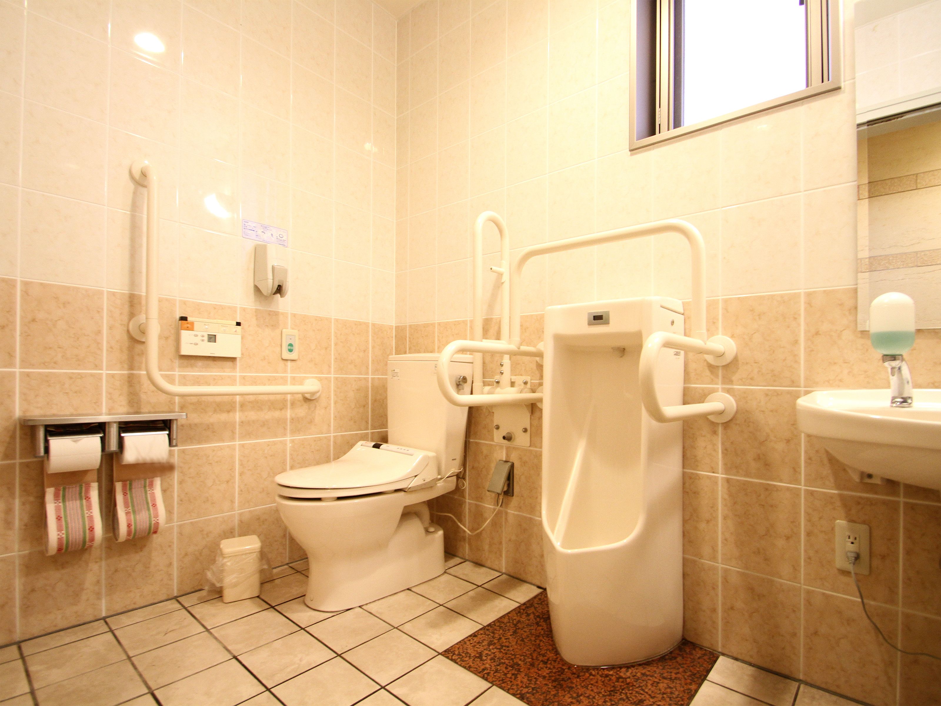 Et badeværelse med toilet, bidet og håndvask.