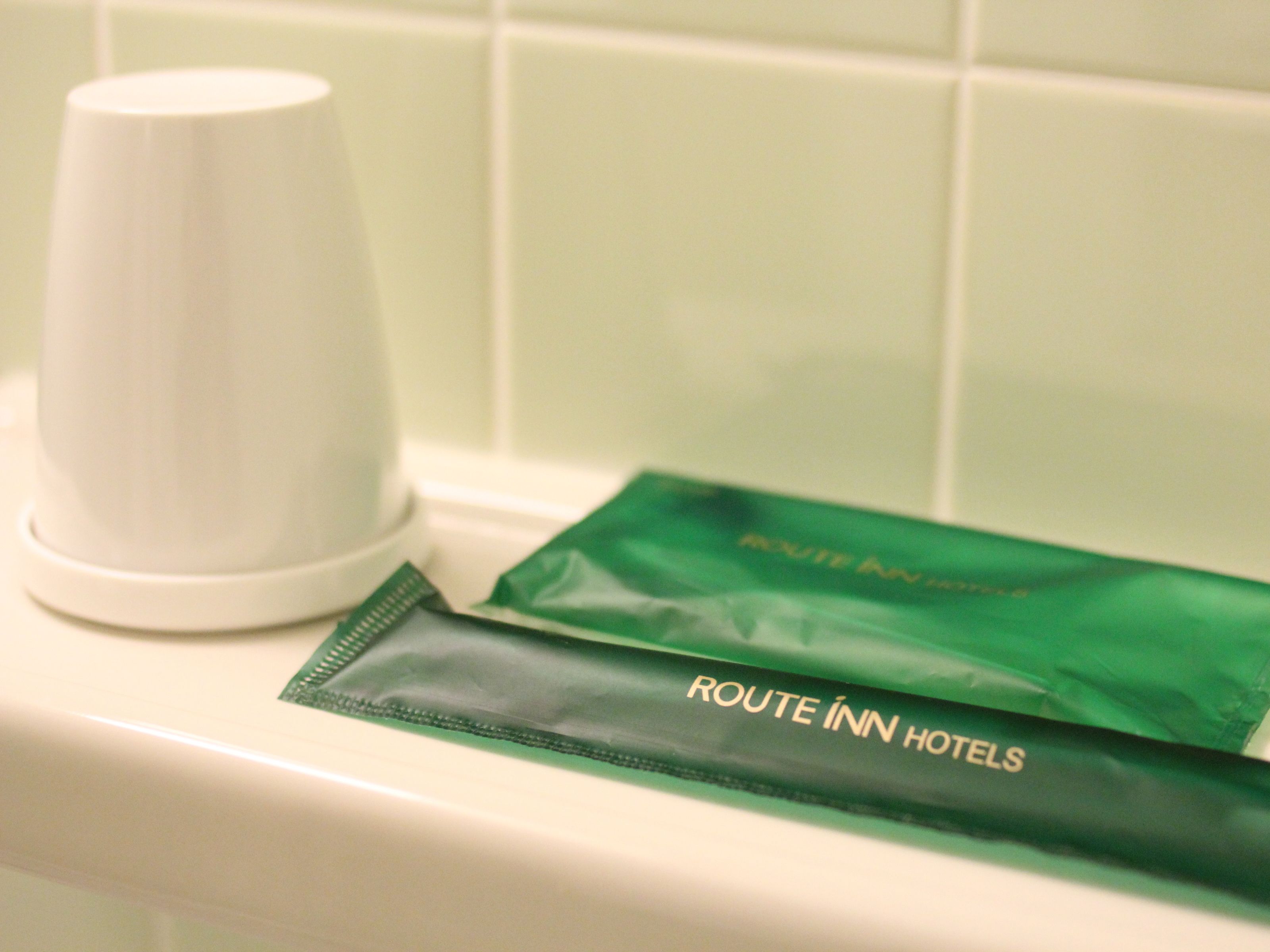 A white urinal and a green bag with "ROUTE INN HOTELS" text.