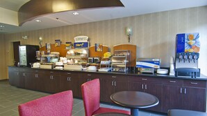 A breakfast bar with a sign that says "EXPRESS start," a juice dispenser, and a coffee machine. There are chairs and tables for guests to sit and eat. - Holiday Inn Express & Suites Jackson / Pearl Intl Airport by IHG (Pearl)