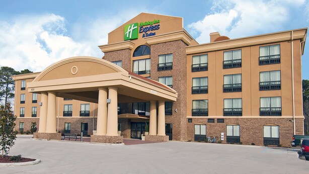 Edificio de Holiday Inn Express & Suites con una entrada destacada, varios balcones y un estacionamiento.