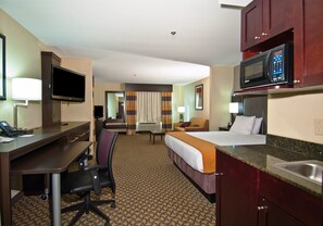 A hotel room with a desk, chair, bed, TV, microwave, and a bathroom. - Holiday Inn Express & Suites Jackson / Pearl Intl Airport by IHG (Pearl)