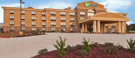 A Holiday Inn Express building with a brick facade, multiple windows, and a covered entrance area.
