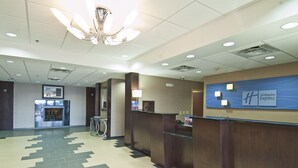 Un vestíbulo de hotel con una recepción, un candelabro y un piso con diseño.