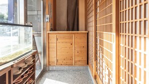 Una habitación japonesa tradicional con puertas correderas, un armario de madera y vistas a través de un ventanal.