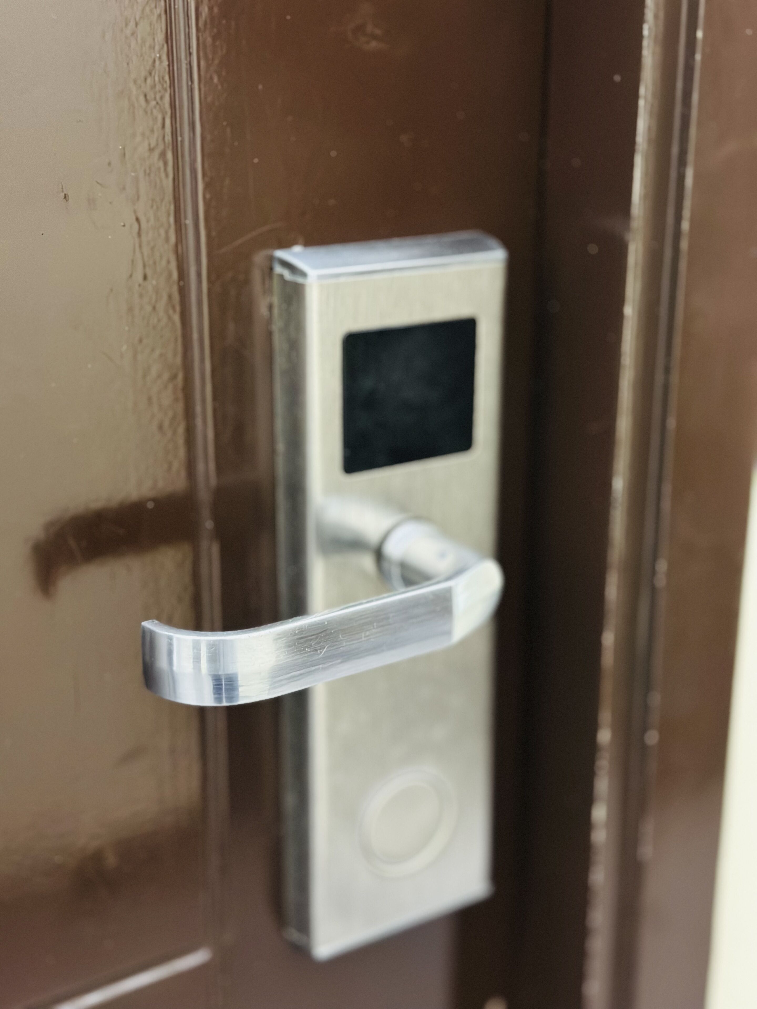 Een deur met een keypad en een metalen handvat.
