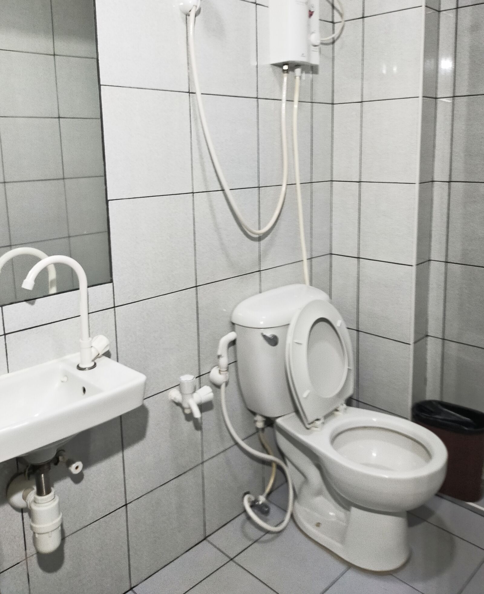 A bathroom with a toilet, sink, and shower.