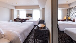 A hotel room with two beds, a desk, a chair, a TV, and a patterned carpet. - Hotel Keihan Sapporo (Sapporo)