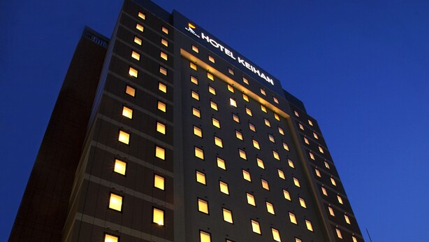 A multi-story hotel building with illuminated windows and a sign reading "HOTEL KEIHAN". - Hotel Keihan Sapporo (Sapporo)