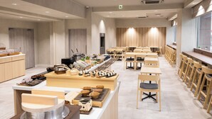 Een modern restaurant met een lange toonbank, houten stoelen en een divers aanbod aan gerechten.