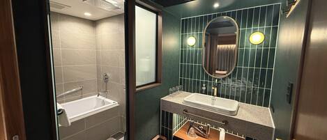 Un baño moderno con una bañera, dos lavamanos, un tocador y un espejo.