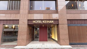 Een moderne hotelentree met een opvallend bord waarop 
