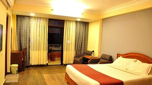 A hotel room with a bed, a desk, a chair, and a small table. - Tibet Guest House (Kathmandu)