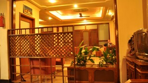A room with a wooden partition, a ceiling fan, and a television on a wooden cabinet. - Tibet Guest House (Kathmandu)