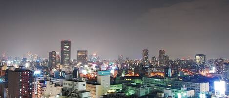 A cityscape at night with illuminated buildings and a dense urban environment.
