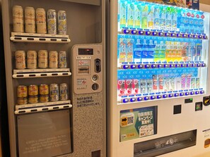 A vending machine with multiple beverage options including cans and bottles, with a digital display and payment interface. - Hotel Route-Inn Sapporo Shiroishi (Sapporo)