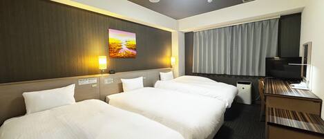 Habitación de hotel con dos camas, un escritorio, un televisor y un cuadro en la pared.