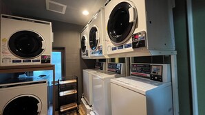 A laundry facility with multiple washing machines and dryers, including a front-loading washer and a top-loading dryer. - Hotel Route-Inn Dai-Ichi Nagano (Nagano)