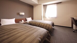 A hotel room with two beds, a desk, a chair, and a window with curtains. - Hotel Route-Inn Dai-Ichi Nagano (Nagano)