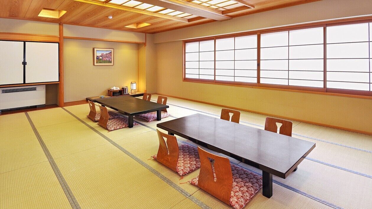 Ein traditioneller japanischer Raum mit Tatami-Boden, einem niedrigen Tisch und Schiebetüren.