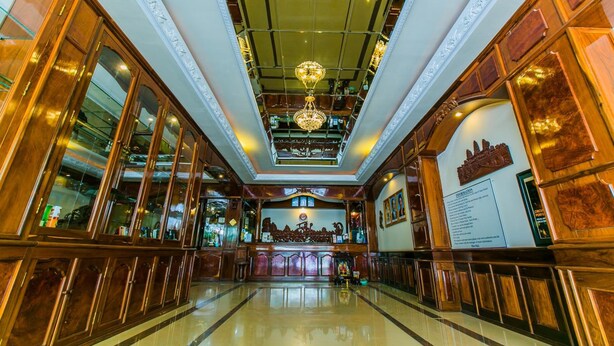 A spacious lobby with a high ceiling, ornate chandeliers, and a central decorative display. - Star Hotel (Battambang)