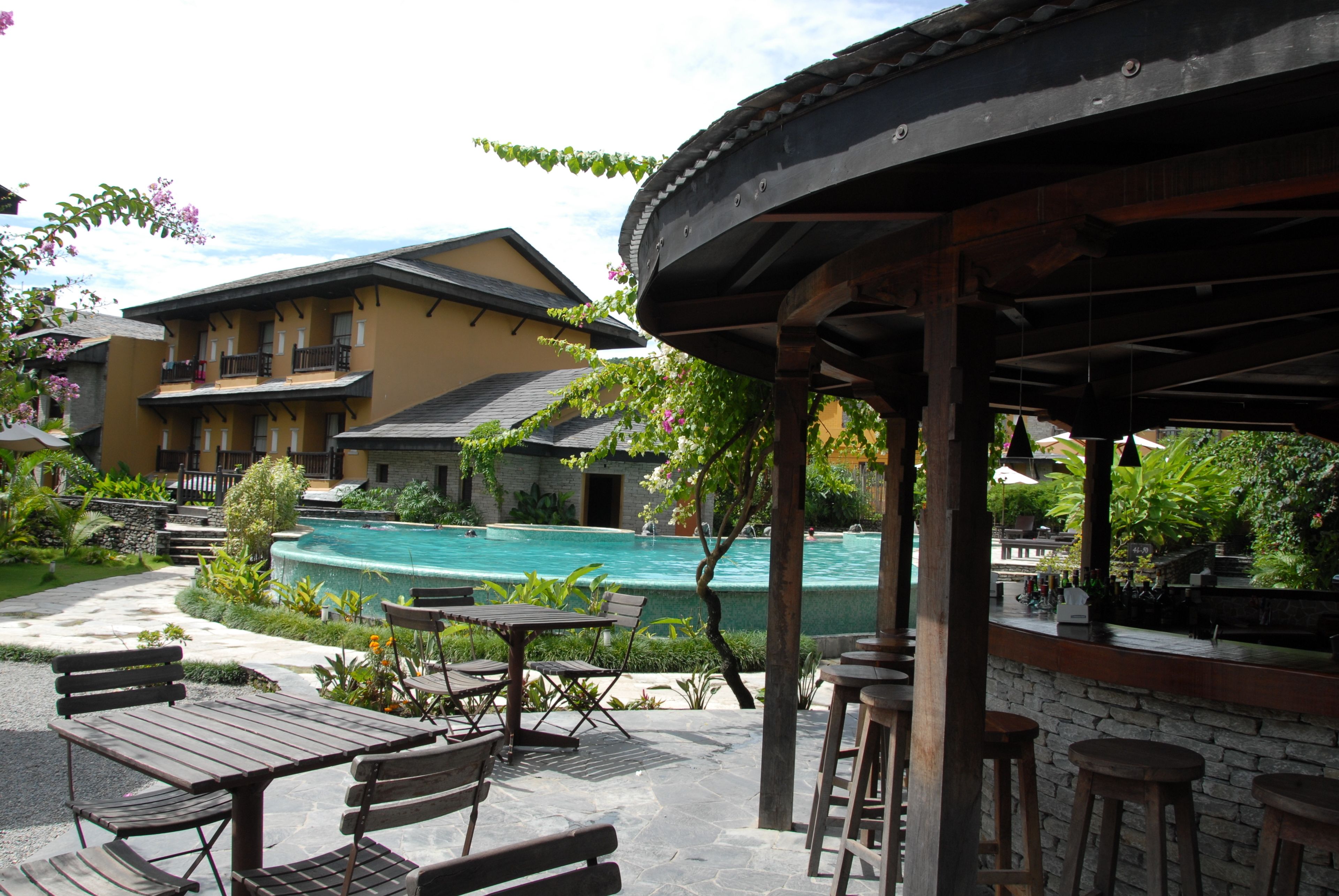 A poolside area with outdoor seating and a building in the background.