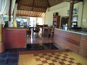A restaurant with wooden furniture, a checkered floor, and a tiled ceiling.