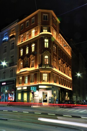 A corner building with a ground-floor entrance, multiple windows, and a sign indicating a business on the ground floor. - Mondial Appartement Hotel (Vienna)