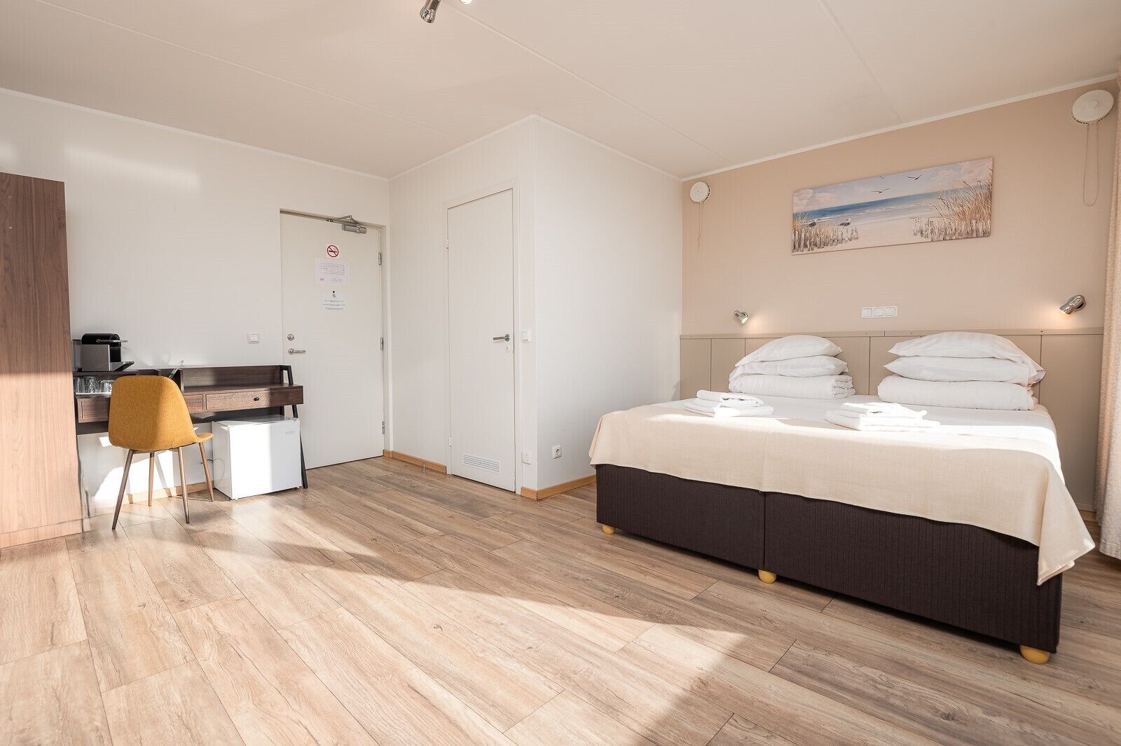 A bedroom with a bed, a desk, and a chair.