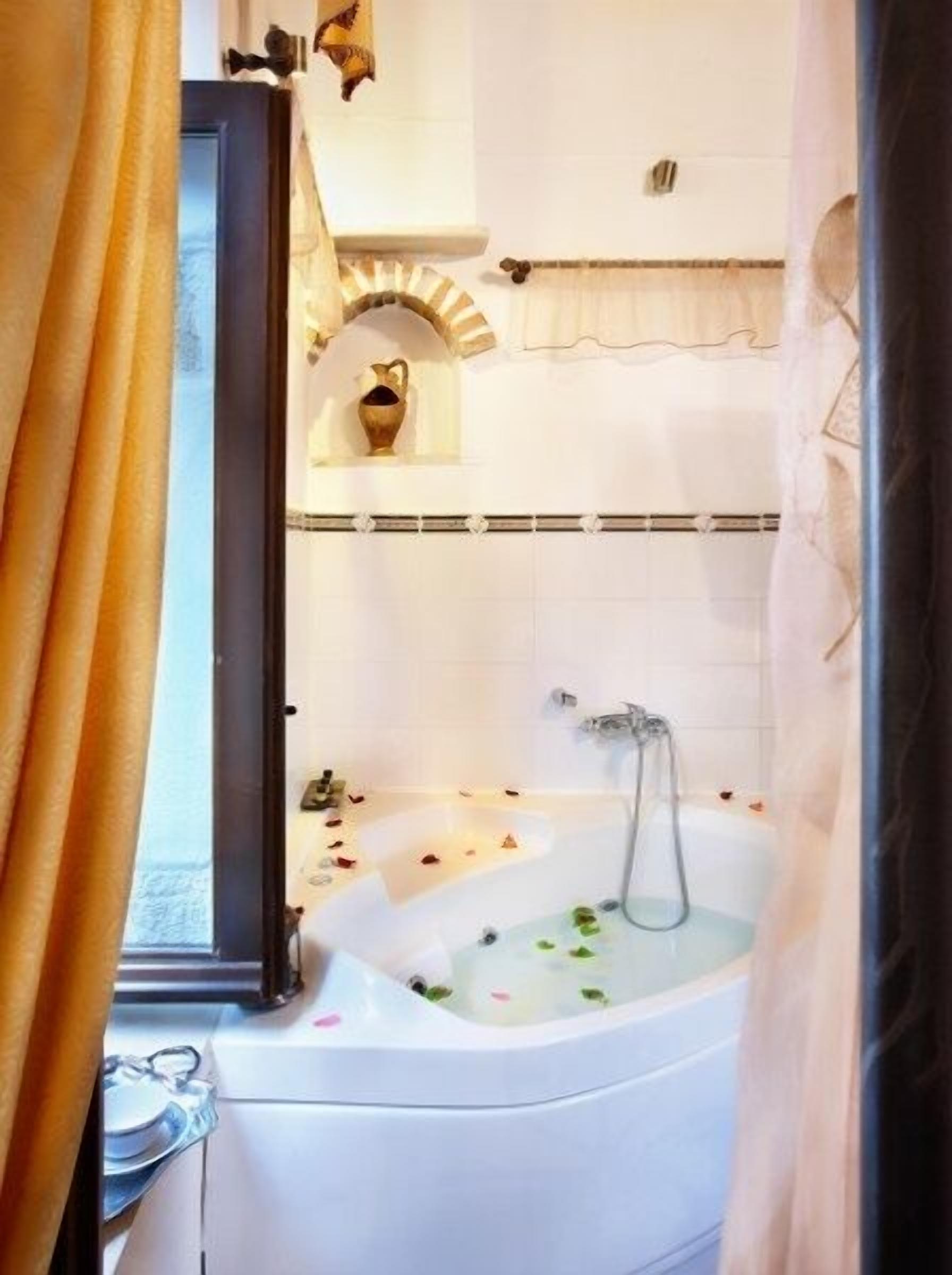 suite, jetted tub, garden view | bathroom | shower, rainfall showerhead, hair dryer, bathrobes
