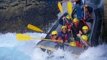 Un grupo de personas en balsas navegando por un río con rápidos.