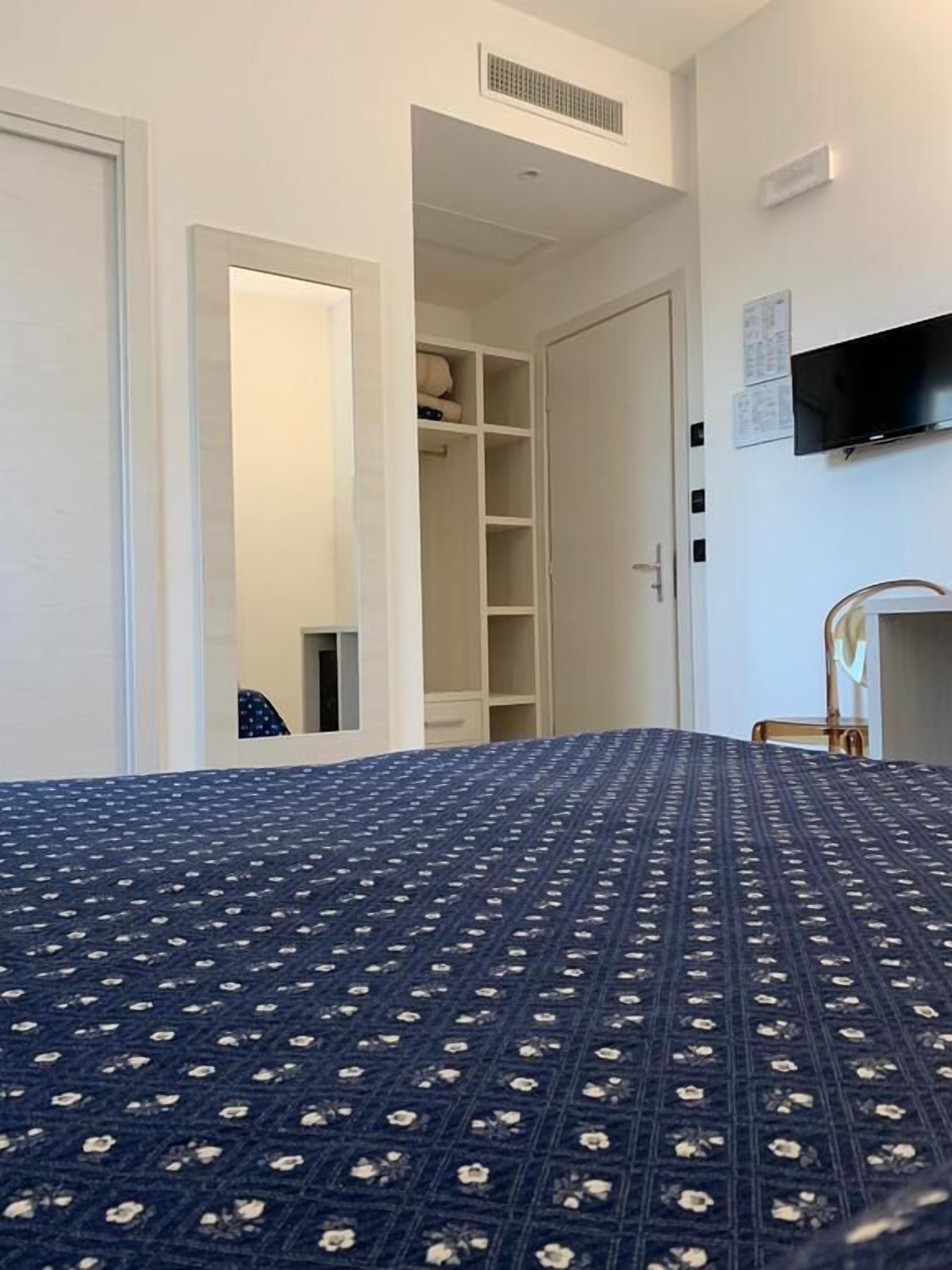 Une chambre à coucher avec un grand lit, une armoire, une télévision et une petite table.