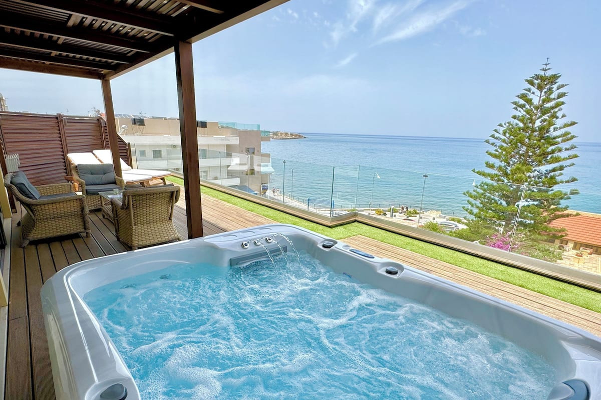 Een hottub op een terras met uitzicht op zee.