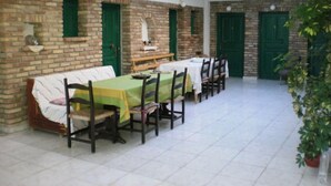 A dining area with brick walls, green doors, and a tiled floor.